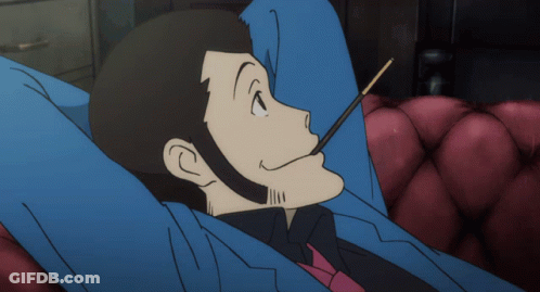 Man In Suit Lying On Couch Eating Stick GIF