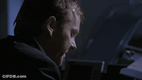 Man In Suit Making Face In Dark GIF