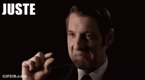 Man In Suit Making Funny Face And Raised Fist GIF
