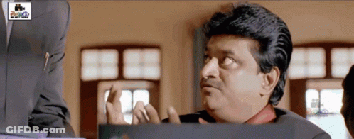 Man In Suit Making Funny Face At Cinema Sign GIF