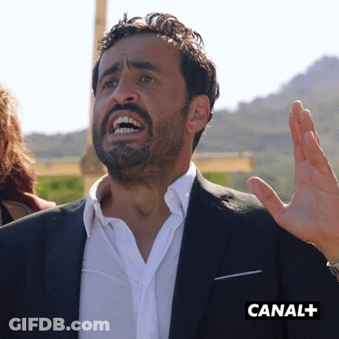 Man In Suit Making Funny Face By Canal+ Sign GIF