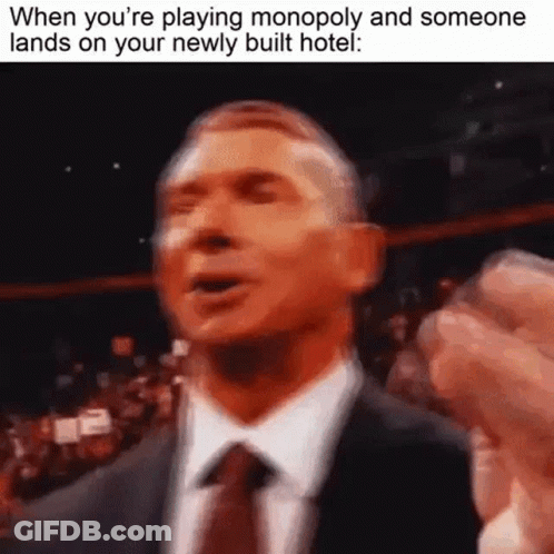 Man In Suit Making Funny Face Playing Monopoly GIF