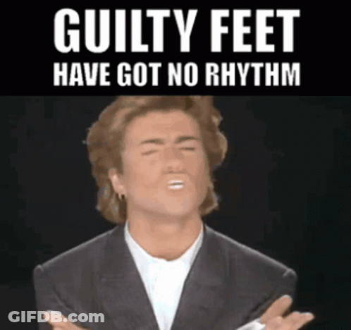 Man In Suit Making Funny Face With Guilty Feet Have Got No Rhythm GIF