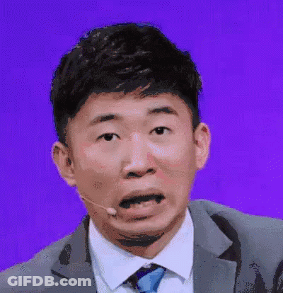 Man In Suit Making Funny Face With Microphone GIF