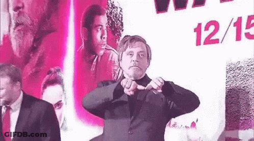 Man In Suit Making Heart Shape In Front Of Movie Poster GIF