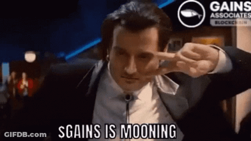 Man In Suit Making Peace Sign Saying S Gains Is Mooning GIF