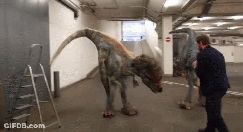 Man In Suit Next To Dinosaur GIF