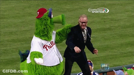 Man In Suit Next To Green Phillies Mascot GIF