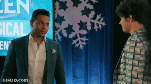 Man In Suit Next To Man At Sign Saying Len GIF