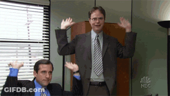 Man In Suit Next To Man With Arms Raised GIF