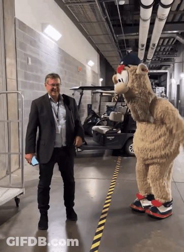 Man In Suit Next To Mascot GIF