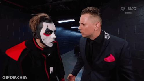 Man In Suit Next To Masked Man GIF
