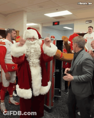 Man In Suit Next To Santa Claus Costume GIF