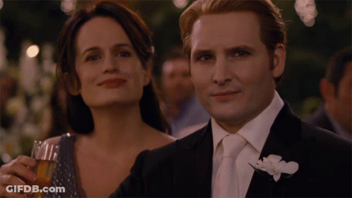 Man In Suit Next To Woman Holding Glass GIF