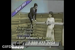 Man In Suit Next To Woman Holding Wood GIF
