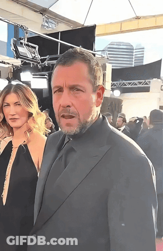 Man In Suit Next To Woman In Black Dress GIF