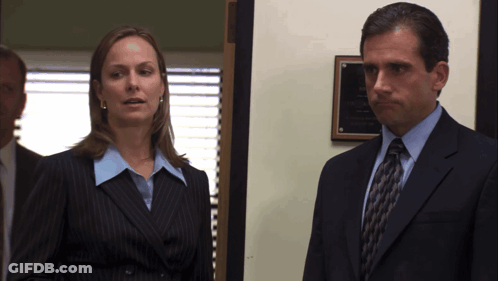 Man In Suit Next To Woman In Blue Shirt GIF