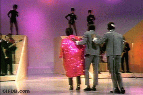 Man In Suit Next To Woman In Pink Coat GIF