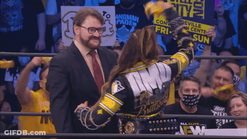 Man In Suit Next To Woman In Wrestling Ring Monroeville Convention GIF