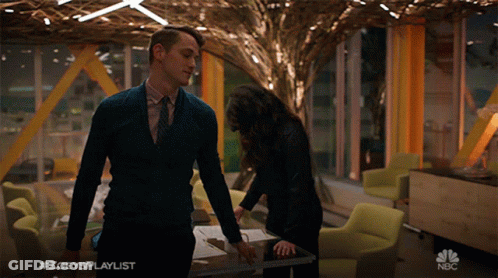 Man In Suit Next To Woman With Hashtag Zoey's Playlist GIF