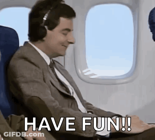 Man In Suit On Airplane Wearing Headphones Saying Have Fun GIF
