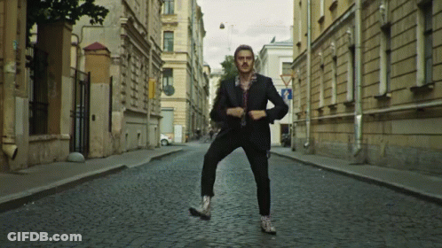 Man In Suit On Cobblestone Street GIF