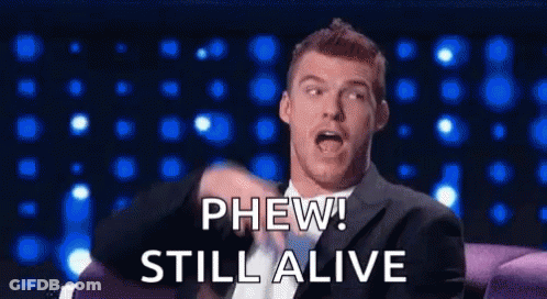 Man In Suit On Couch Saying Phew Still Alive GIF