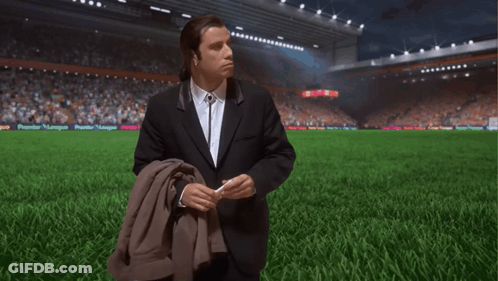 Man In Suit On Soccer Field With Premier League Banner GIF