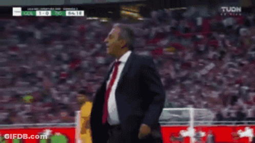 Man In Suit On Soccer Field With Referee GIF