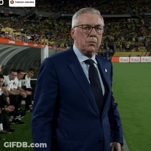 Man In Suit On Soccer Field With Turkish Airlines Ad GIF