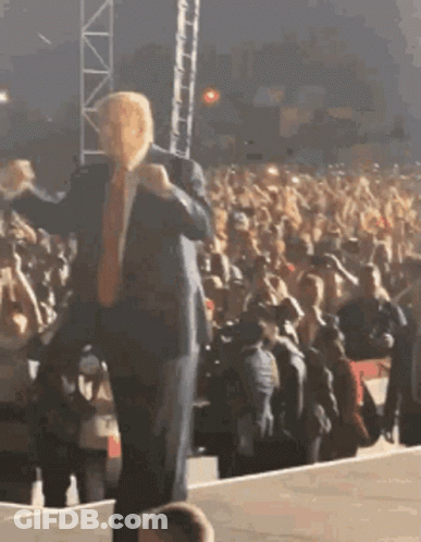 Man In Suit On Stage In Front Of Crowd GIF