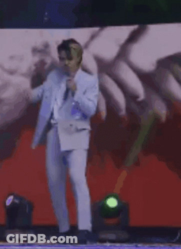 Man In Suit On Stage With Microphone GIF