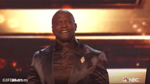 Man In Suit On Stage With NBC Logo GIF