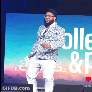 Man In Suit On Stage With Screen Saying Colle & P GIF