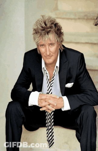 Man In Suit On Stairs With Hands Folded GIF