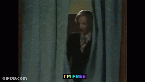 Man In Suit Peeking Out Behind Curtain GIF