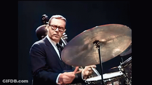 Man In Suit Playing Drum Set GIF