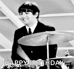 Man In Suit Playing Drum Set Smiling GIF
