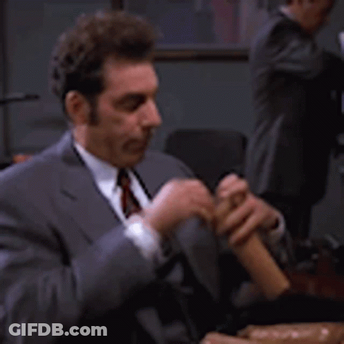 Man In Suit Playing Flute At Table GIF