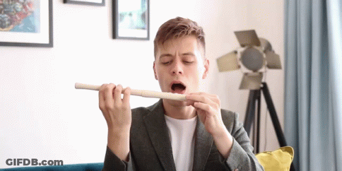 Man In Suit Playing Flute With Open Mouth GIF