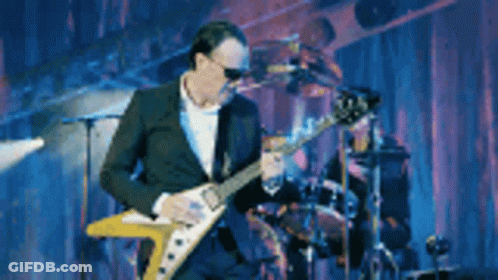 Man In Suit Playing Guitar On Stage GIF