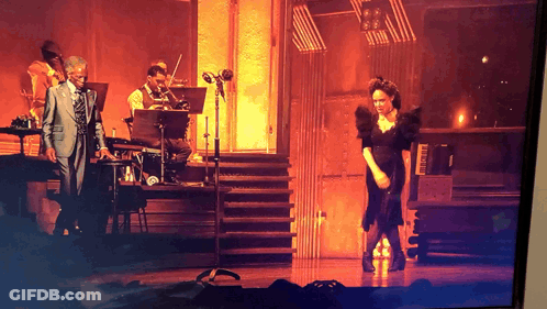 Man In Suit Playing Piano Woman In Black Dress Dancing GIF