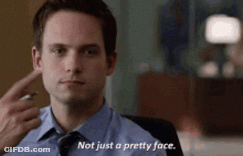 Man In Suit Pointing At Ear Saying Not Just A Pretty Face GIF