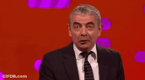 Man In Suit Pointing Up Saying It's Mr. Bean GIF