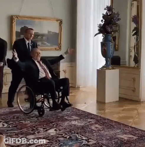 Man In Suit Pushing Man In Wheelchair GIF