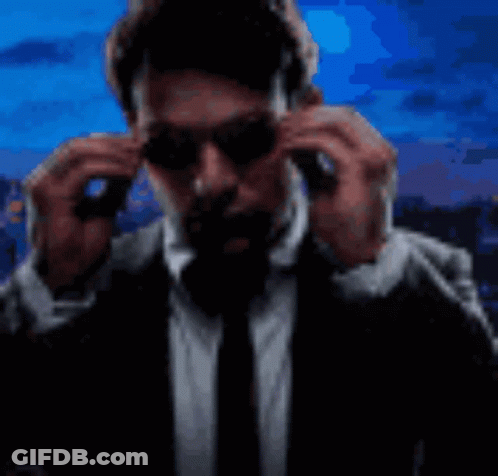 Man In Suit Putting On Sunglasses GIF