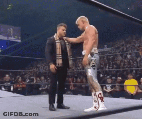 Man In Suit Putting Scarf On Wrestler GIF
