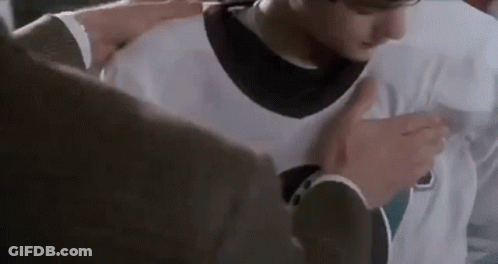 Man In Suit Putting White Jersey On Young Man GIF