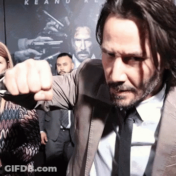 Man In Suit Raising Fist Keanu Reeves Poster GIF