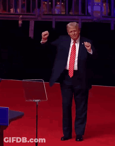Man In Suit Raising Fist On Red Carpet GIF